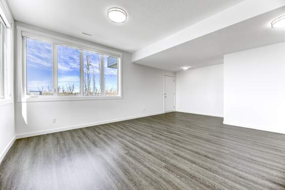 A room with a large window and wooden flooring.
