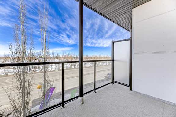 A balcony with a view of a road and trees.