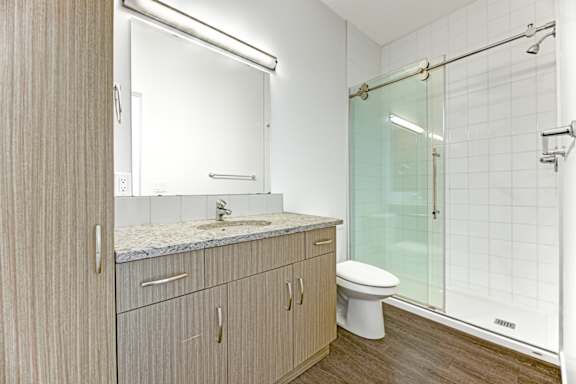 A bathroom with a toilet, sink, and shower.
