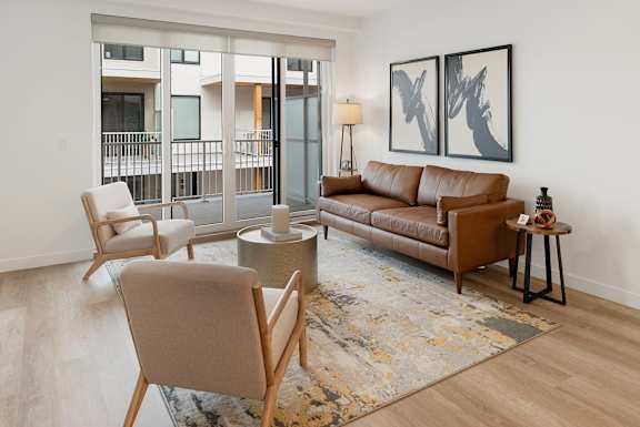 a living room with a couch and chairs and a rug