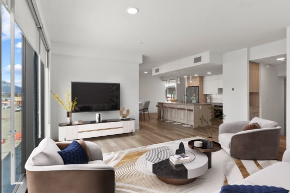 a living room with white walls and a large flat screen tv on the wall