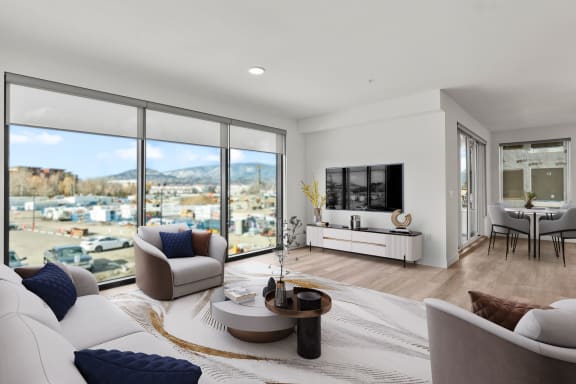 a living room with white walls and floor to ceiling windows