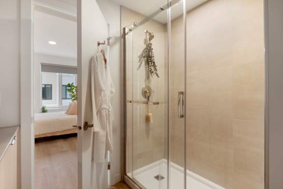 a bathroom with a shower and a robe in it