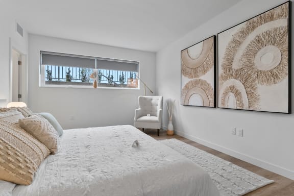 a bedroom with a large bed and two large pictures on the wall