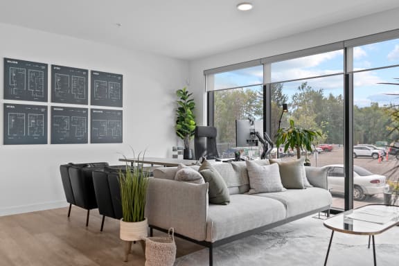 a living room with a couch and chairs in front of a large window