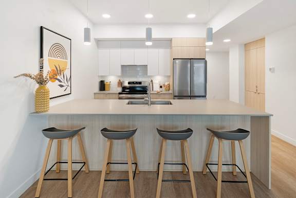a kitchen with a large island with three bar stools
