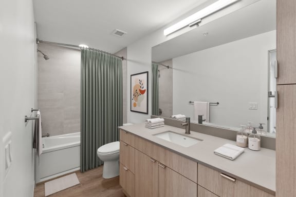 a bathroom with a toilet sink and shower in a 555 waverly unit