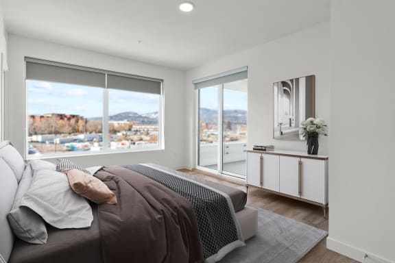 a bedroom with a large window and a large bed