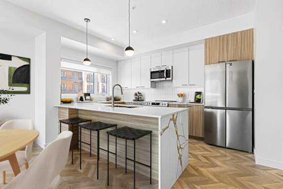 A modern kitchen with a white countertop and stainless steel appliances.