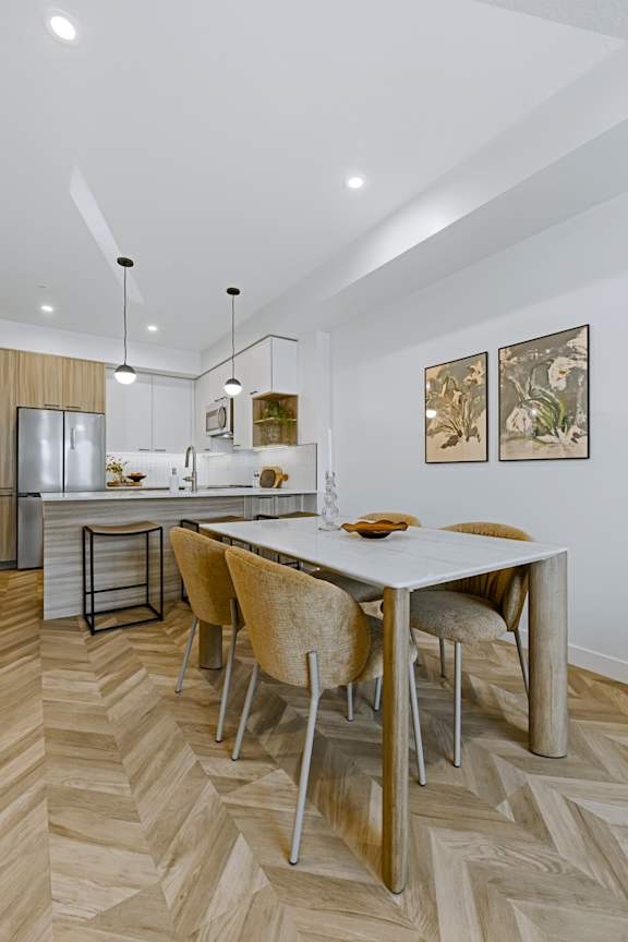 A modern kitchen with a dining table and chairs.
