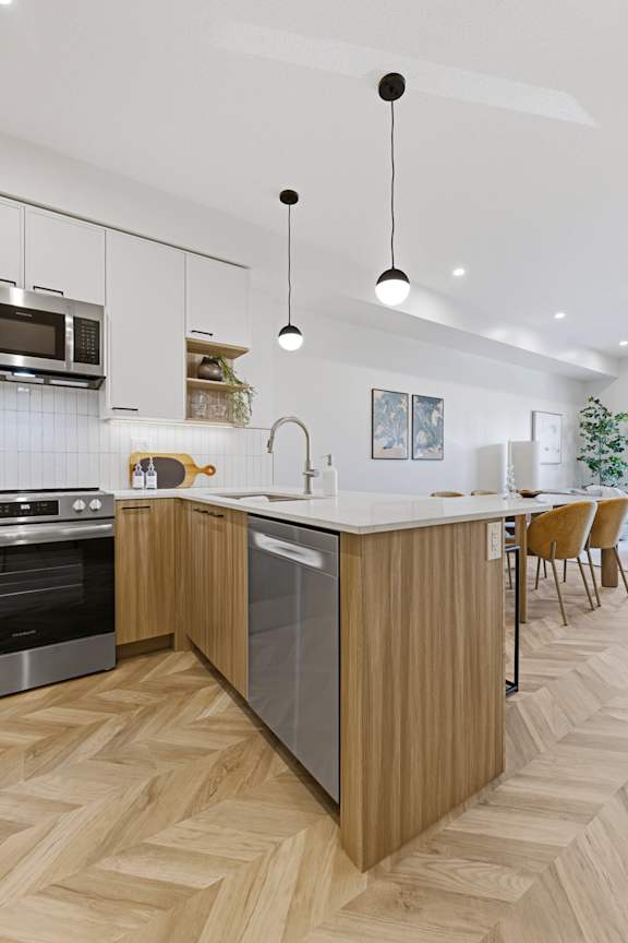 A modern kitchen with wooden flooring and a large island.