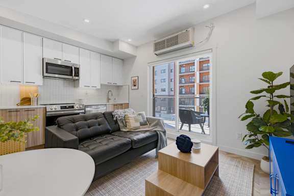 A modern living room with a grey sofa and a white coffee table.