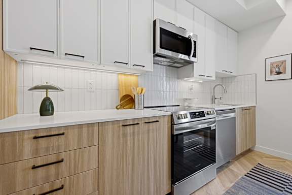 A modern kitchen with wooden cabinets and stainless steel appliances.
