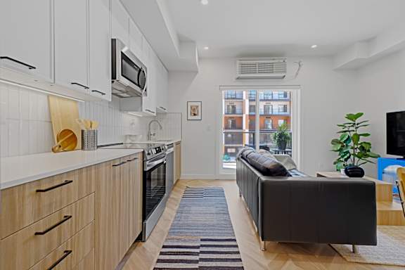 A modern kitchen with wooden cabinets and a black sofa.