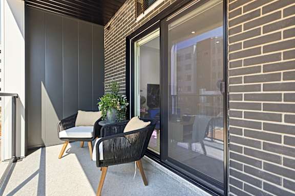 A patio with a chair and a table with a potted plant on it.