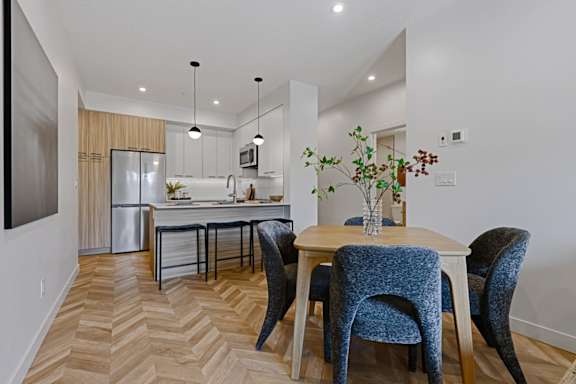 A kitchen with a dining table and chairs.
