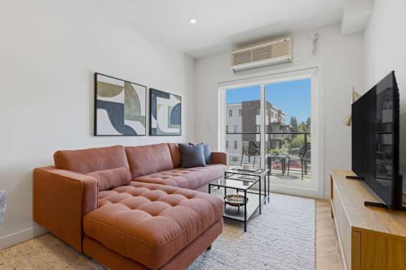 A living room with a brown couch and a television.
