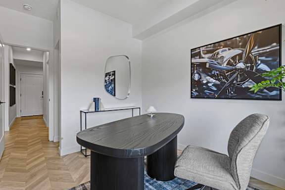 A modern living room with a round table and a grey armchair.