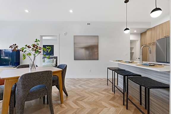 A kitchen with a dining table and chairs.
