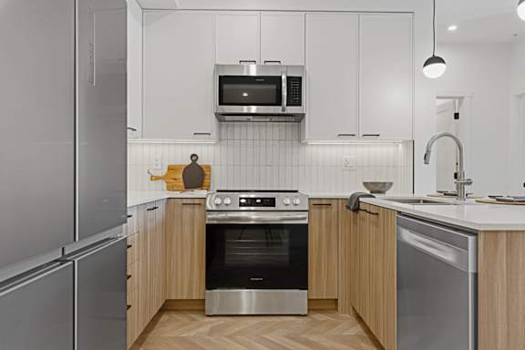A modern kitchen with stainless steel appliances and wooden cabinets.