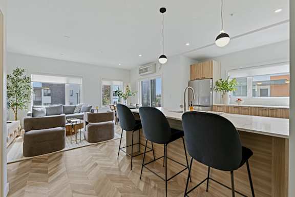 A modern kitchen with a dining area and a living room.