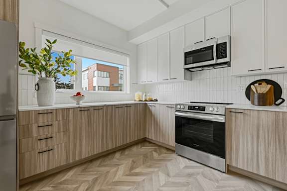 A kitchen with wooden cabinets and a black oven.