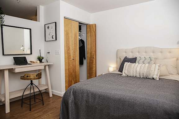 A bedroom with a bed, desk, and chair.