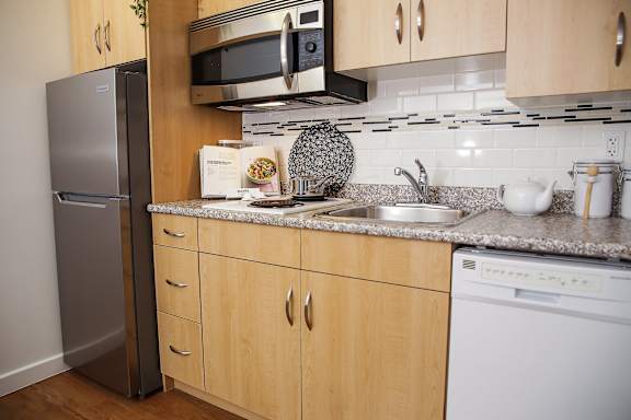 A kitchen with wooden cabinets and a granite countertop.