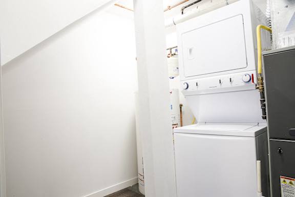 A white oven is in a room with white walls.