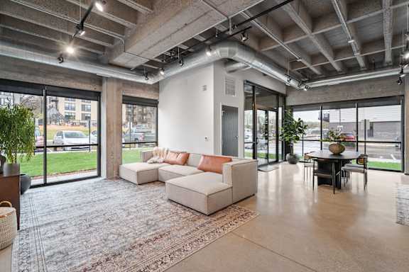 A spacious living room with a couch, a chair, and a table.