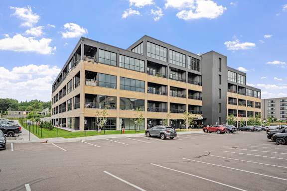 A large multi-story building with a parking lot in front.
