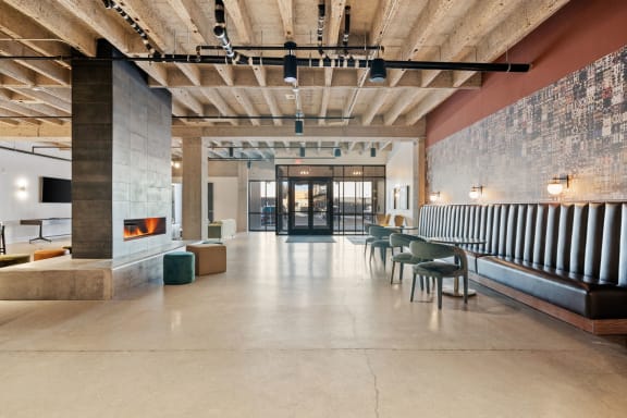 the lobby of a building with a fireplace and tables and chairs