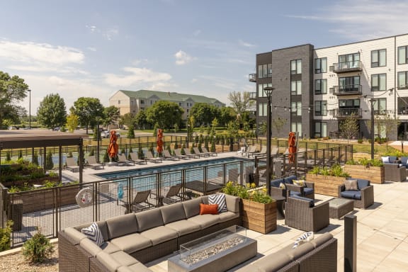 an outdoor lounge area with a pool at an apartment complex