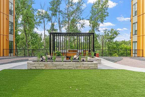 A black metal structure sits in the middle of a grassy area.