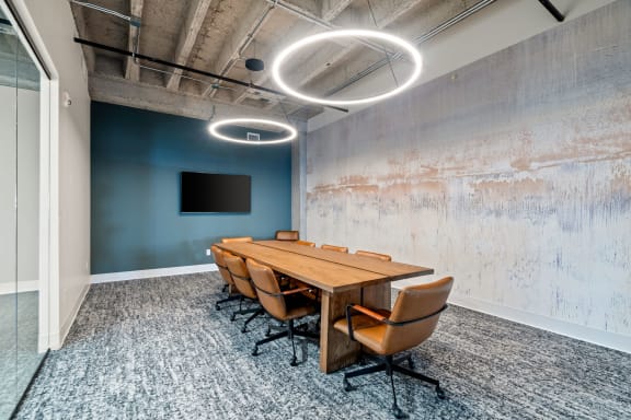 a conference room with a wooden table and chairs and a tv on the wall