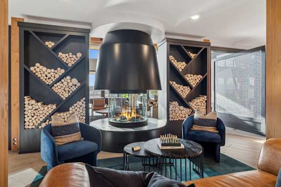 A modern living room with a fireplace and a large black lamp.