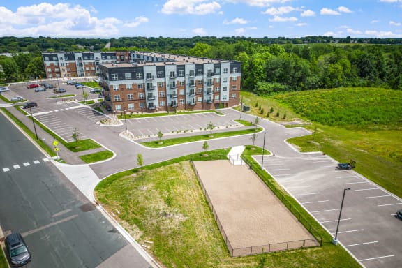 an aerial view of a parking lot and a large apartment building