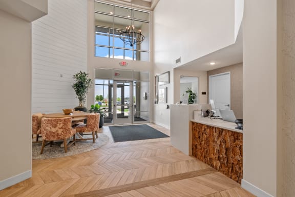 a lobby with a reception desk and a table with chairs