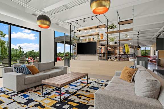 A modern living room with a grey sofa and a wooden coffee table.