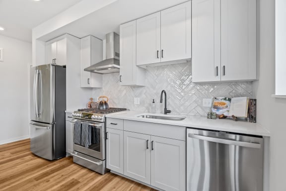 a kitchen with white cabinets and stainless steel appliances