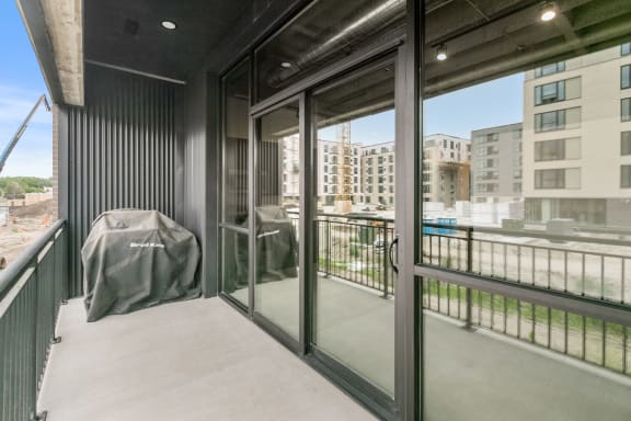 a balcony with a table and chairs and a large window