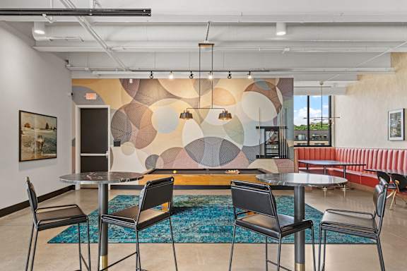 A modern dining room with a large mural on the wall.