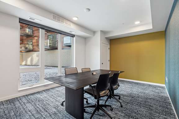 A conference room with a table and chairs.