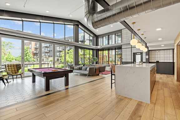 A large room with a pool table and a reception desk.