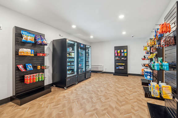 A row of black vending machines are lined up against a wall.