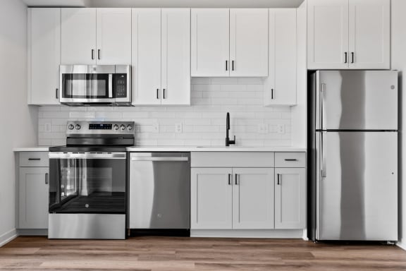 a kitchen with white cabinets and stainless steel appliances