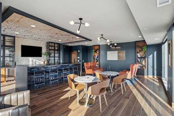 A modern dining area with a bar and a television.