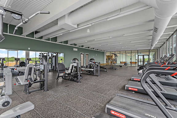 A gym with treadmills, weights, and exercise equipment.