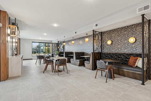A modern dining area with a glass wall and a patterned wallpaper.