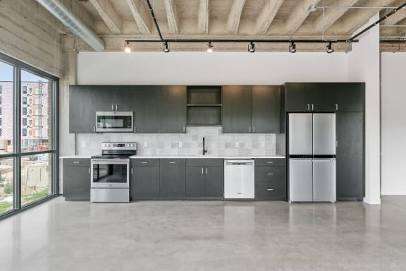 a kitchen with gray cabinets and stainless steel appliances